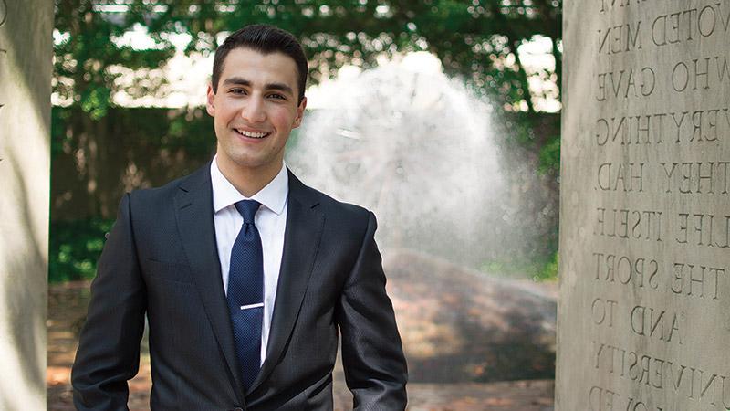 Business student in suit in front of fountain